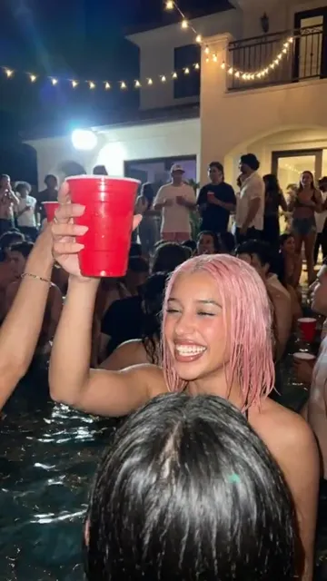 Vídeo vertical: chica de pelo rosa en una fiesta en la piscina